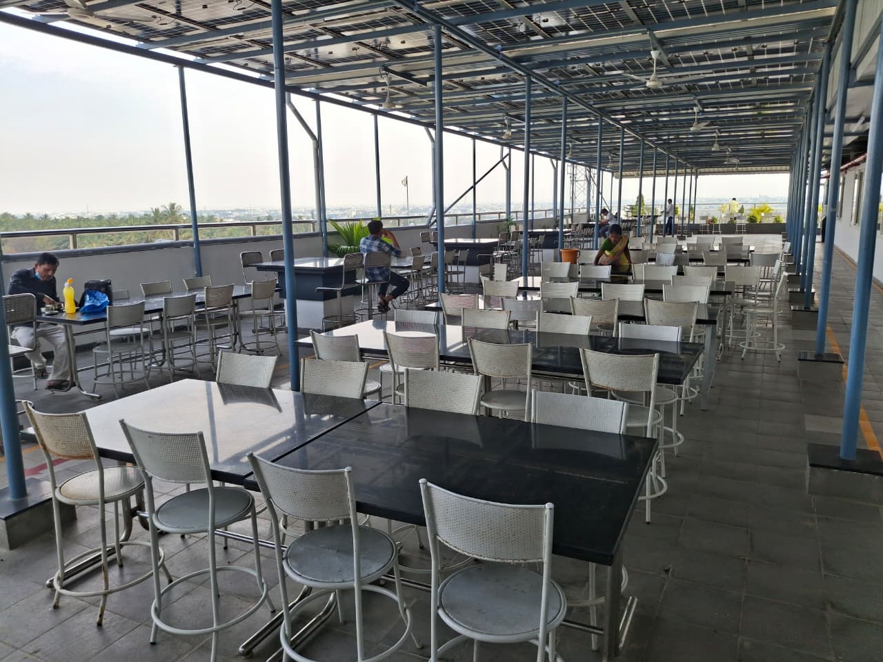 Rooftop dining hall under solar panels — seating for 400+ workers