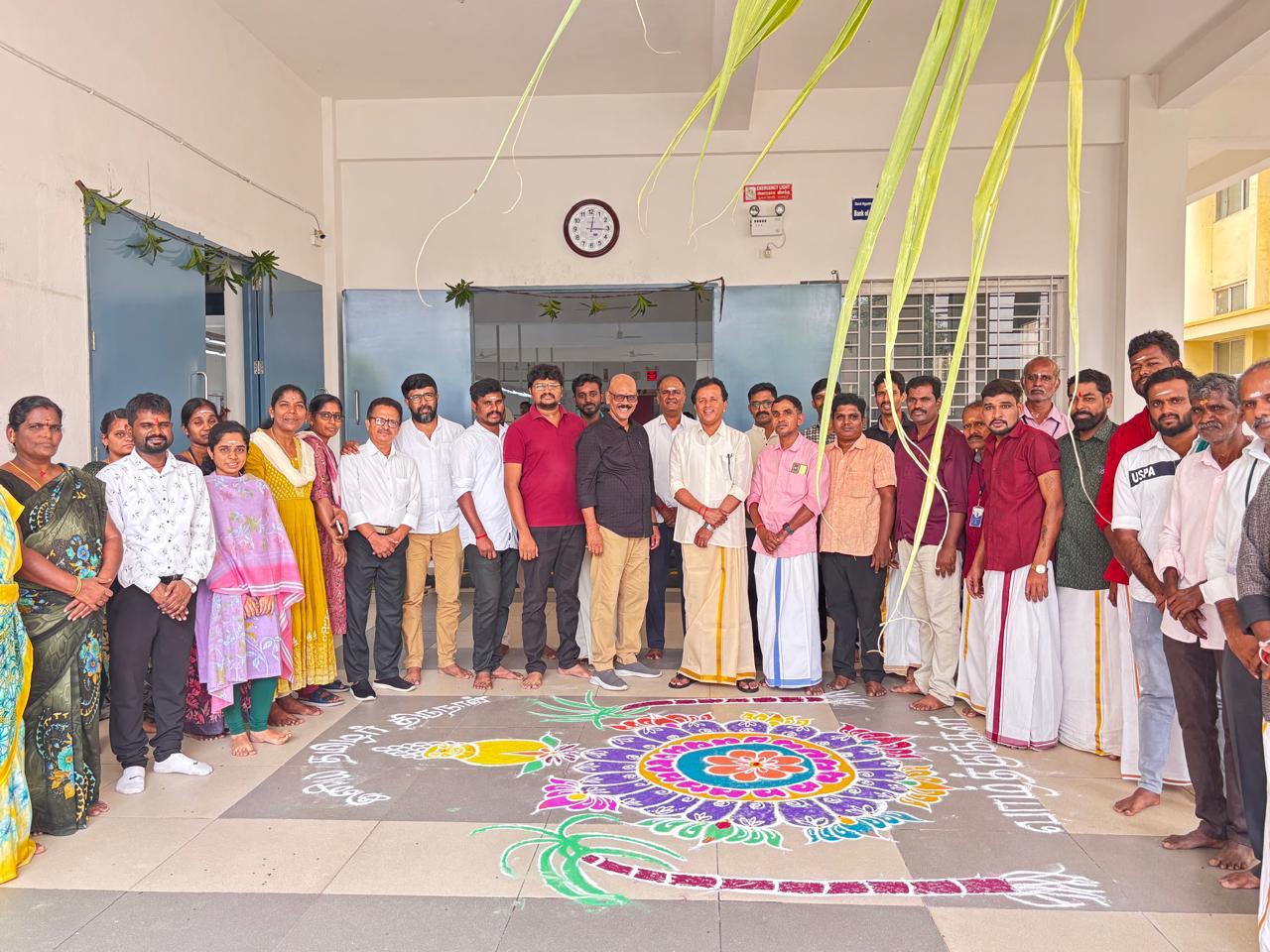 Pongal celebration — team gathered around traditional kolam rangoli